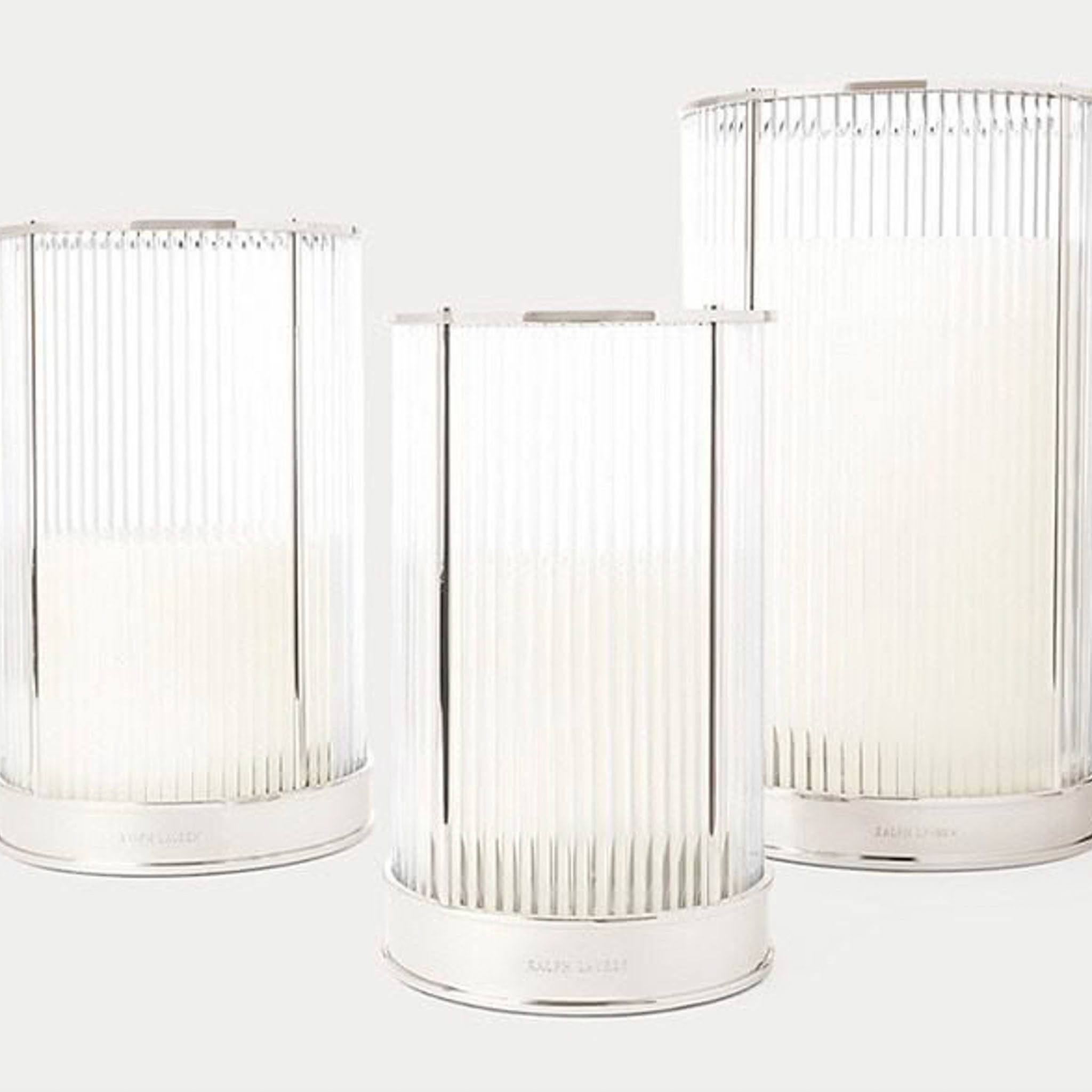 Three cylindrical white pleated lamps on light background