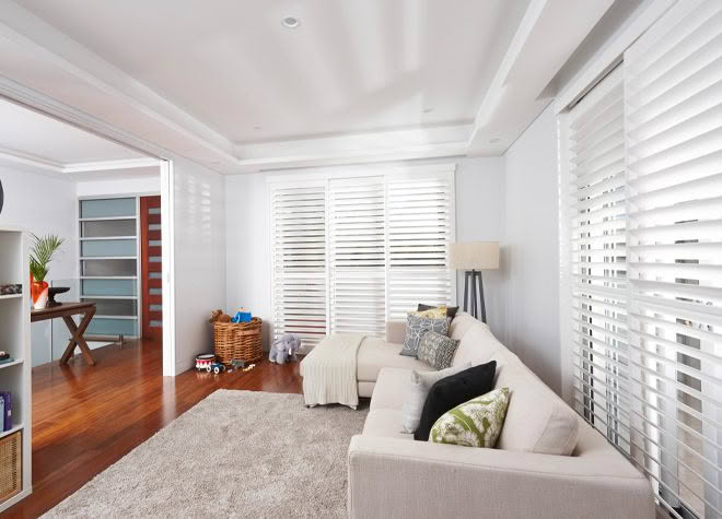 Bright modern living room with white shutters and sofa