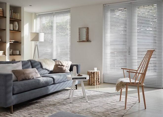 Modern living room with gray sofa and white blinds
