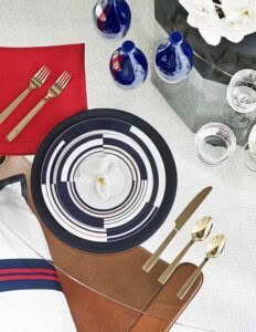 Elegant table setting with striped plates and gold cutlery