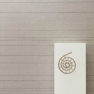 Spiral sculpture on white pedestal against striped wall