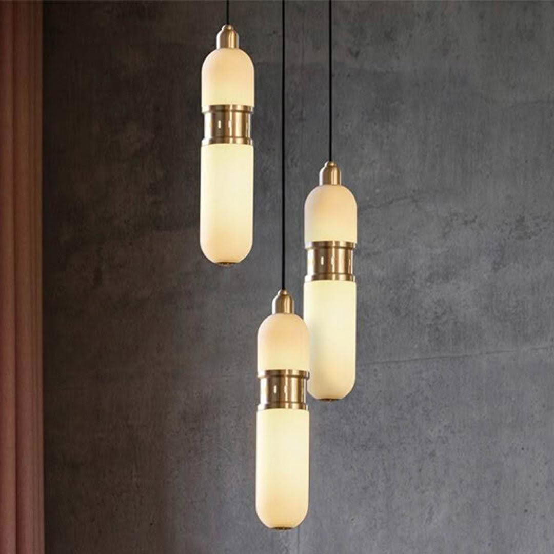 Elegant pendant lights with gold accents against gray wall