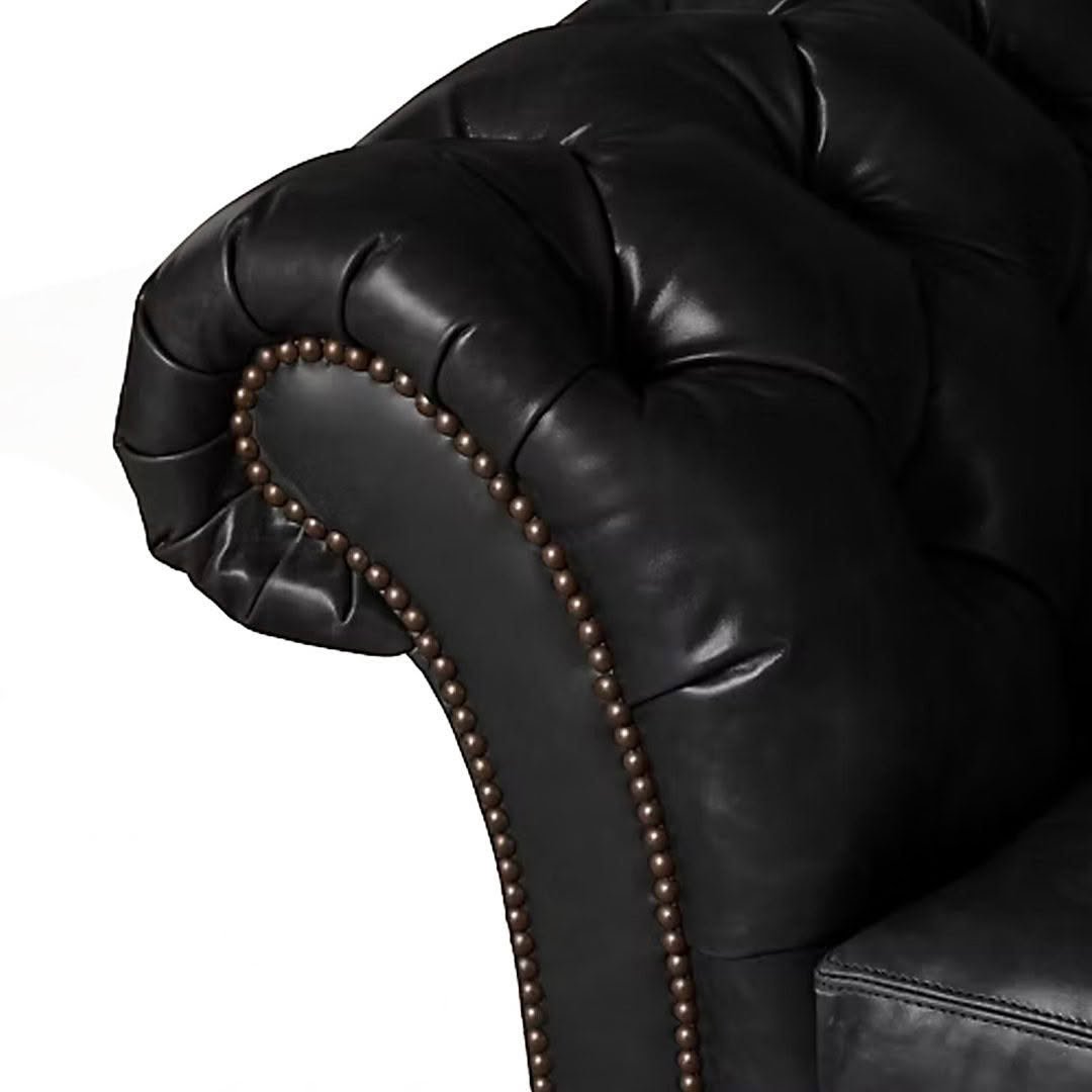 Close-up of black leather chair with brass nailhead trim