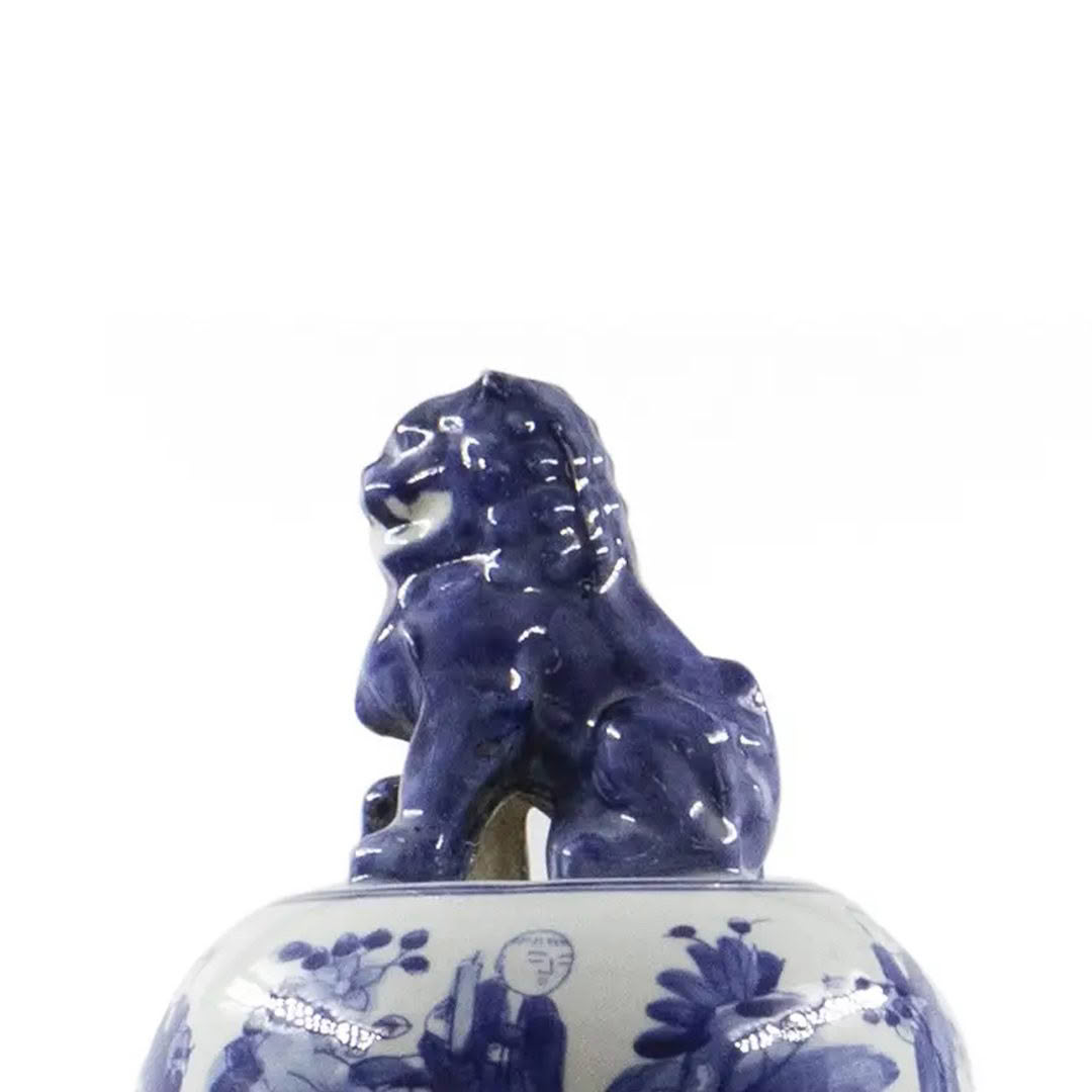 Blue ceramic lion figurine on floral patterned vase