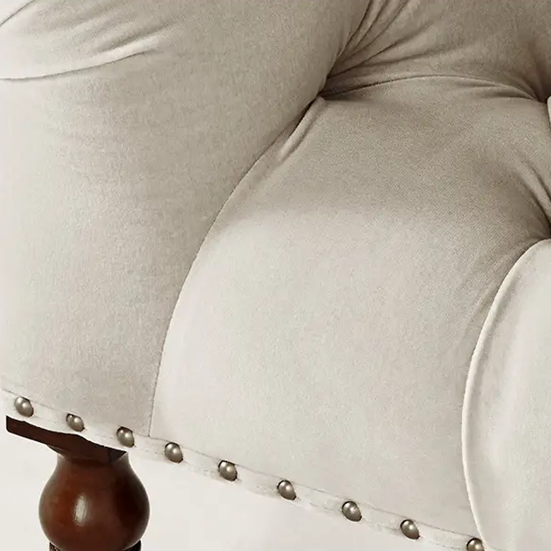 Mayfair-Tufted-Chair Close-up of beige upholstered chair with nailhead trim