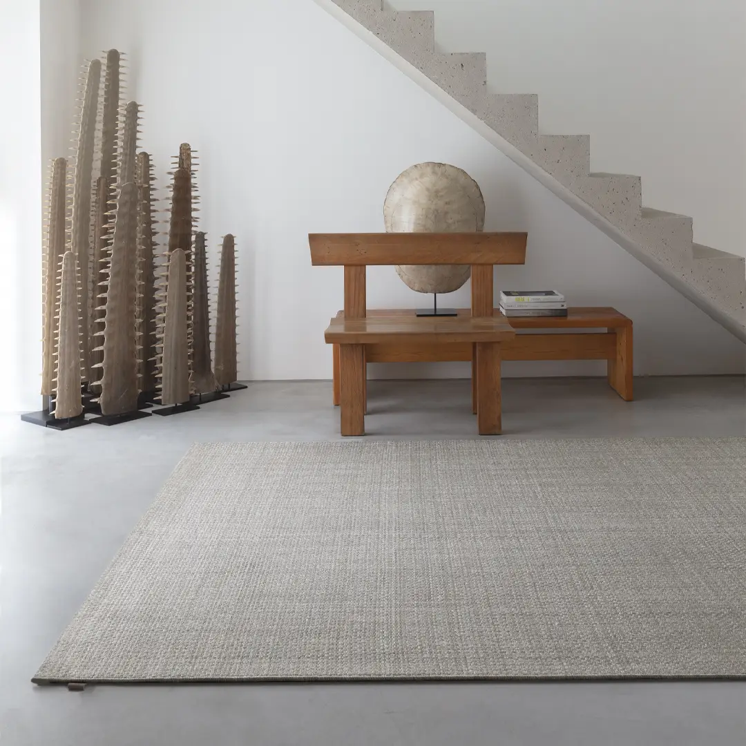 Minimalist interior with wooden bench and textured sculptures