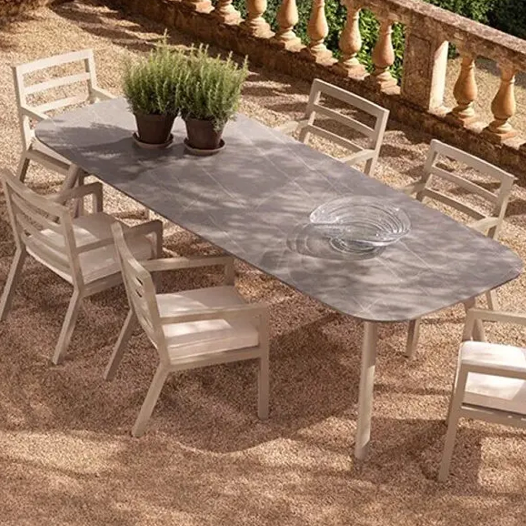 Outdoor dining table set with chairs and potted plants