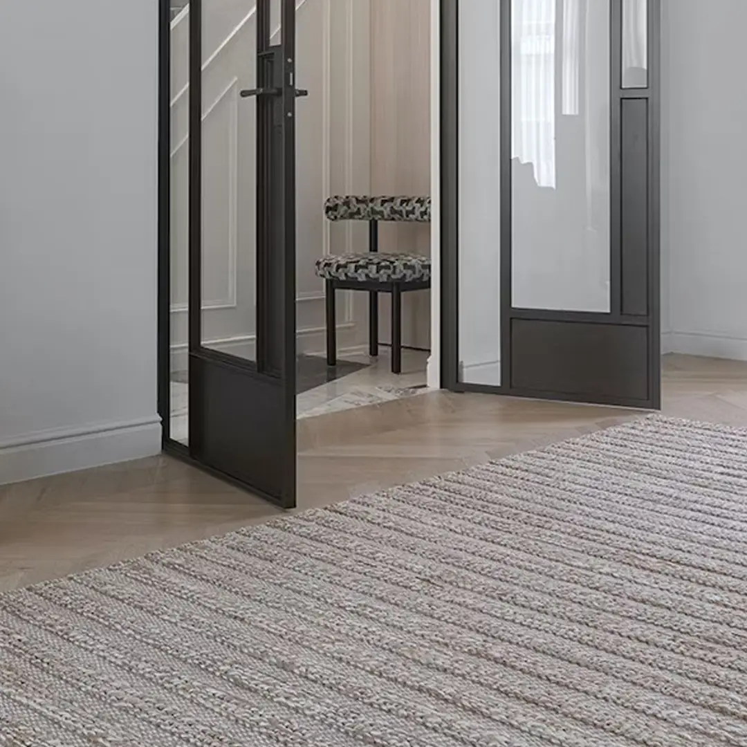 Elegant interior with mirror, chair, and textured rug