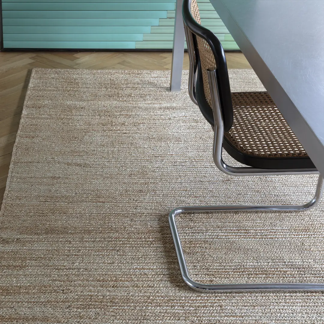 Modern chair on textured woven rug with wooden floor