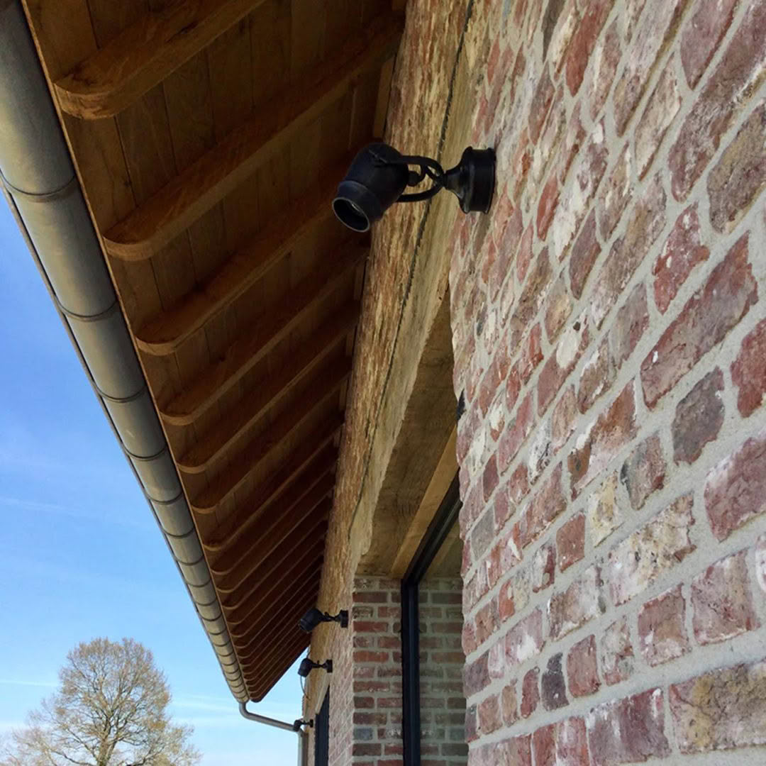 MICRO-ON-ROUND-BASE_1 Security cameras on brick building under wooden eaves