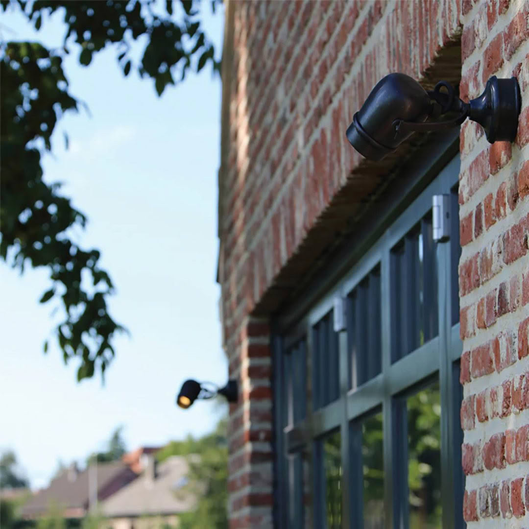 MICRO-ON-ROUND-BASE_2 Lamp on brick building wall near window