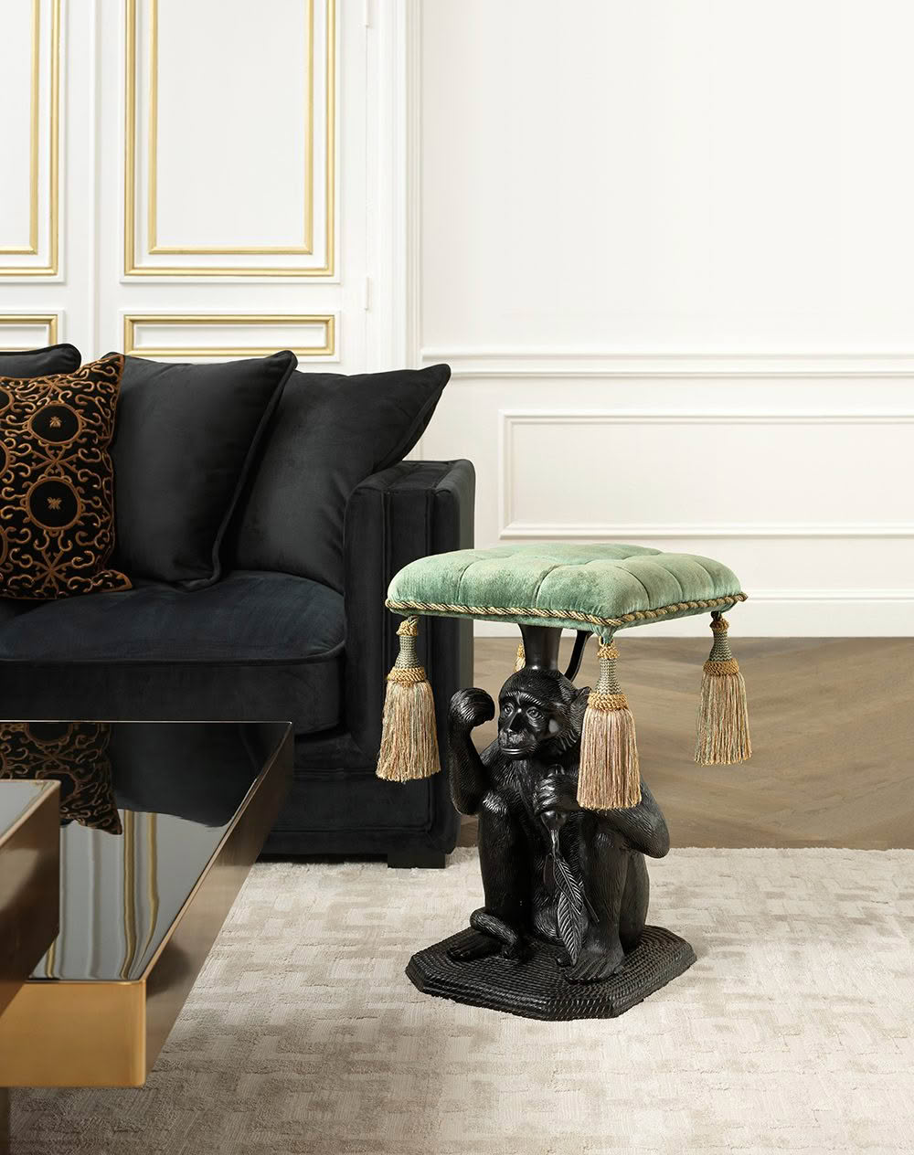 Sculpted monkey holding a tasseled cushion in elegant room