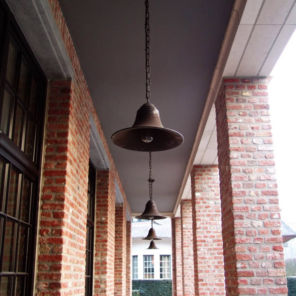 Antique bell pendant lights along brick corridor
