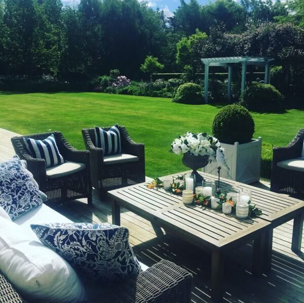 Outdoor garden dining setup with lush greenery and furniture