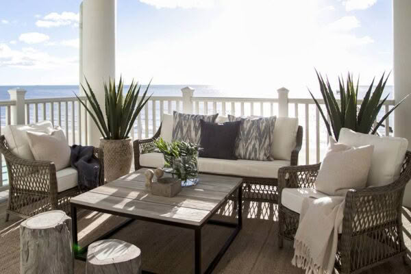 Cozy oceanfront balcony with rattan furniture