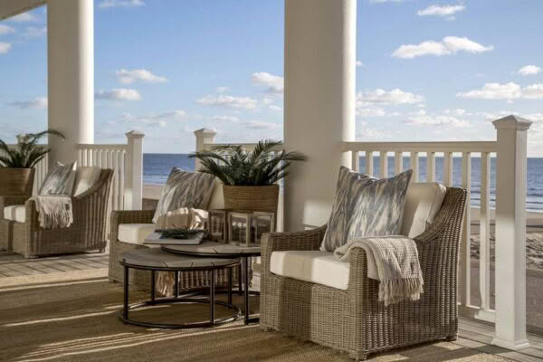 Oceanfront porch with wicker furniture and cozy cushions