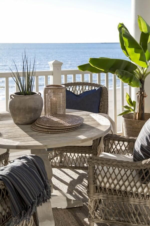 Cozy seaside balcony with wicker furniture and plants
