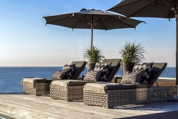 Oceanfront deck with wicker loungers and umbrellas