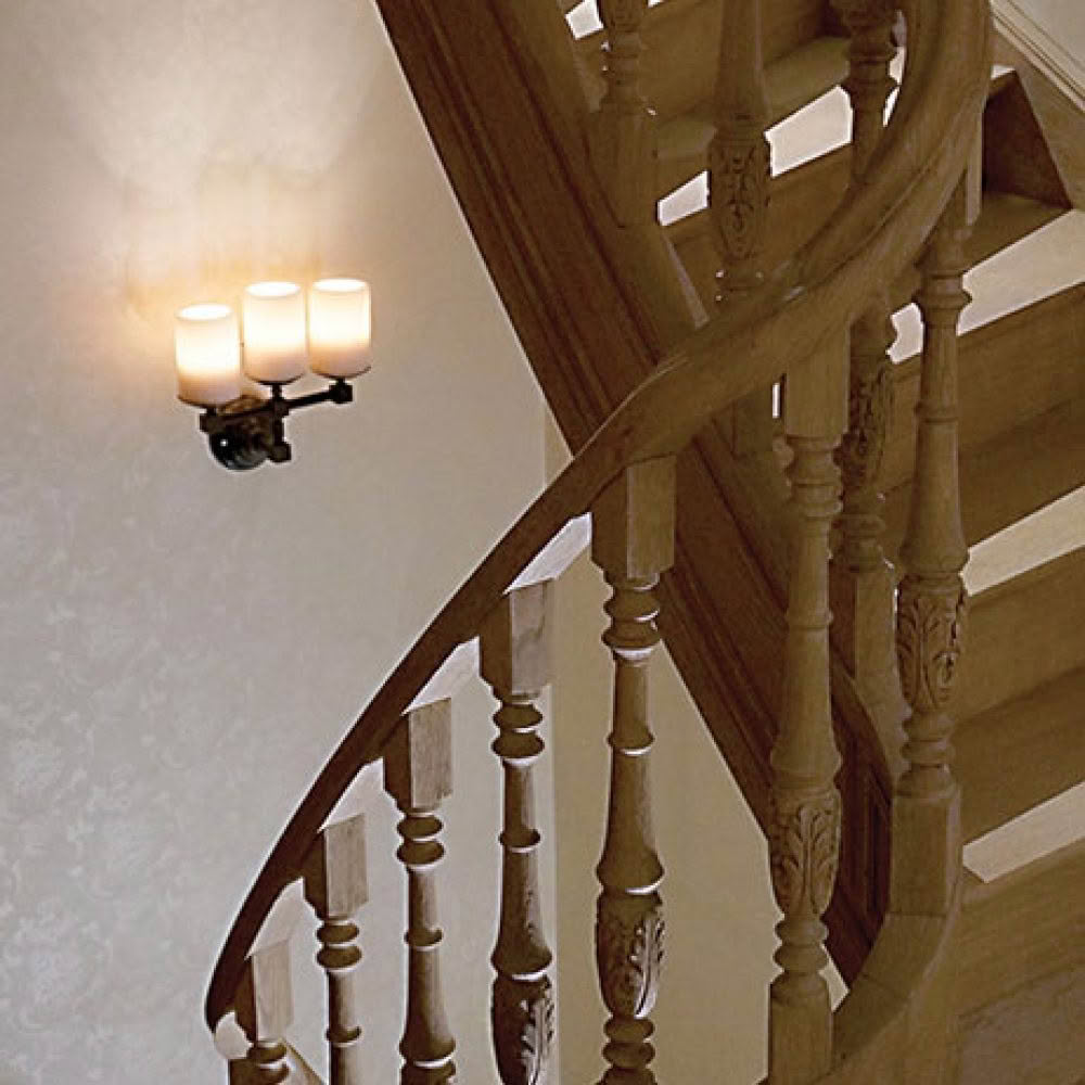 Elegant wooden staircase with wall-mounted candle sconce
