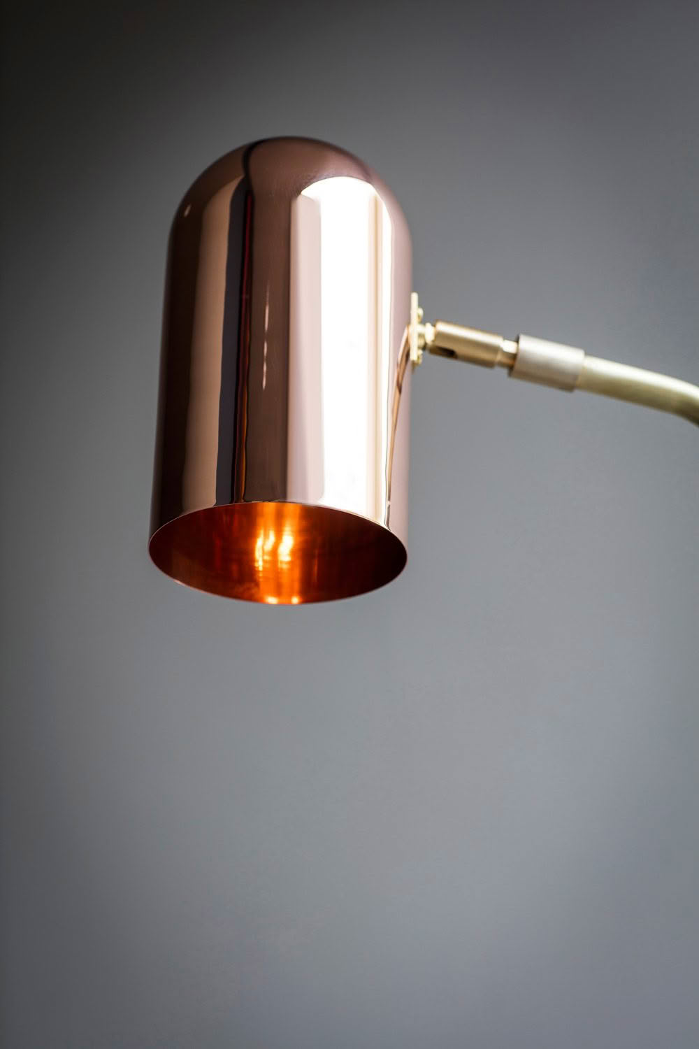 Sleek copper pendant lamp against gray background