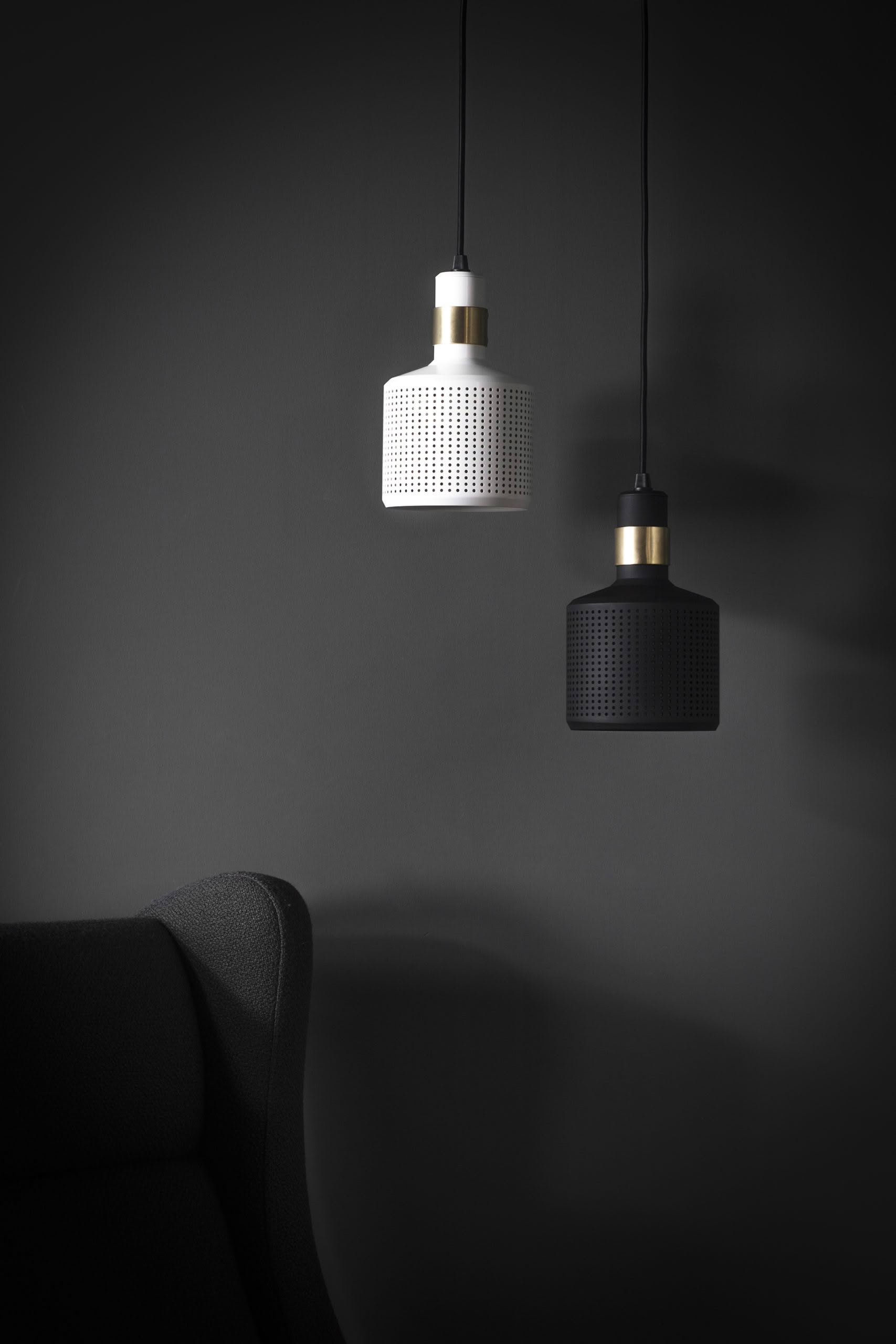 Modern pendant lights above dark corner couch