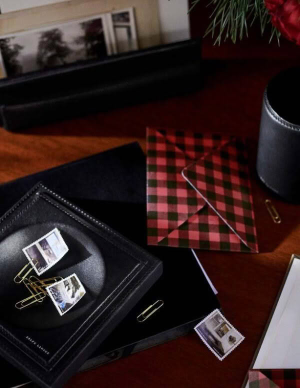 Elegant desk setup with photo album and plaid envelope