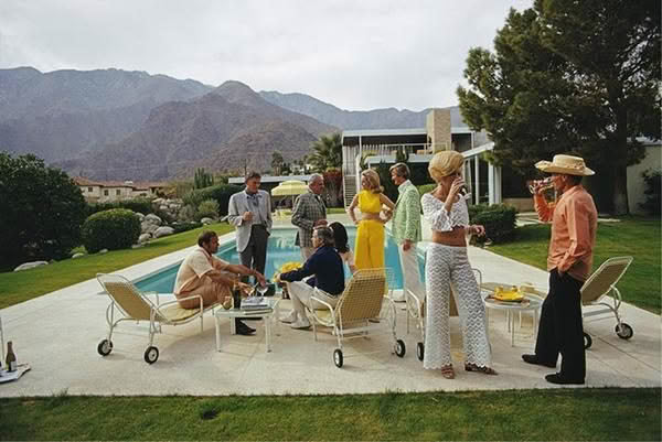 Group enjoying poolside gathering in a lush mountain backdrop