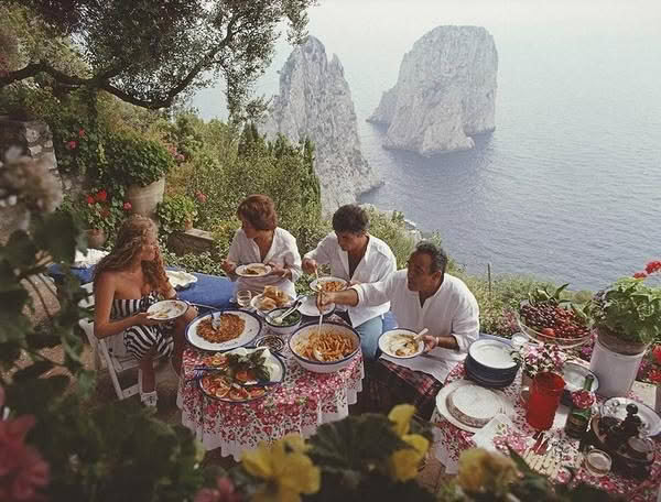 Group dining outdoors overlooking scenic sea cliffs