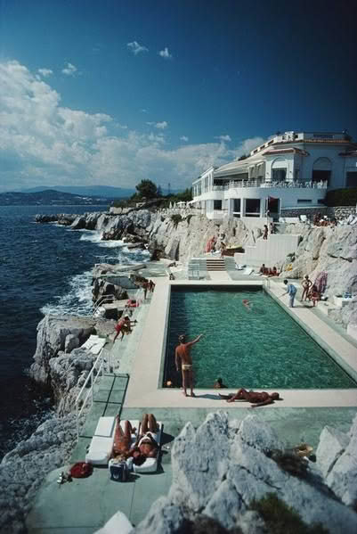 Seaside pool by rocky coast under blue sky