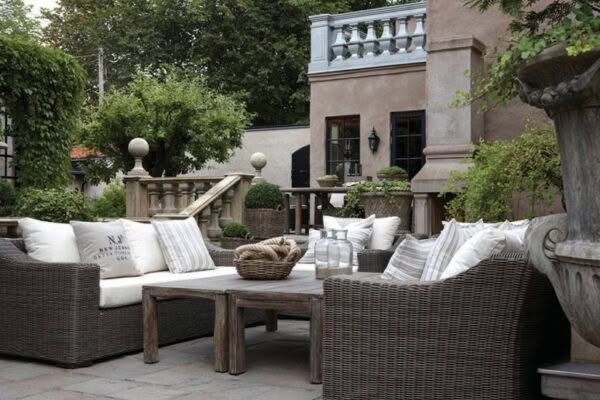 Elegant outdoor patio with wicker furniture and cushions