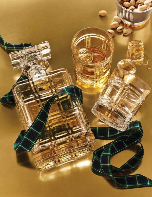 Luxury perfume bottles with tartan ribbon on golden surface