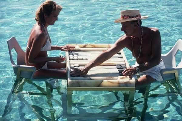Couple playing backgammon at table in water