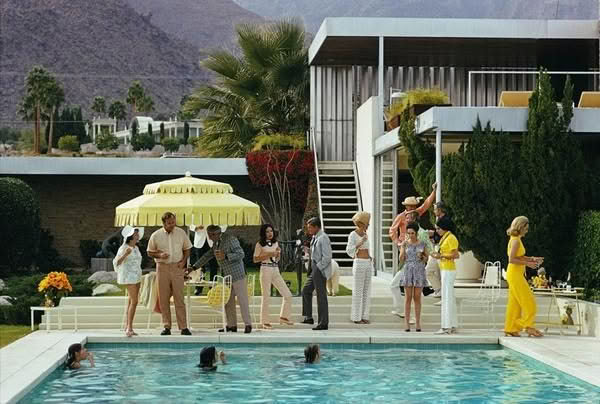 Retro pool party with stylish guests and mountain backdrop
