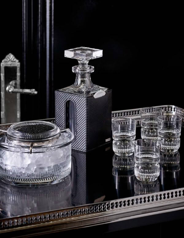 Elegant crystal decanter and glasses on reflective surface