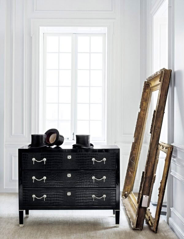 Elegant black dresser with hat in bright white room