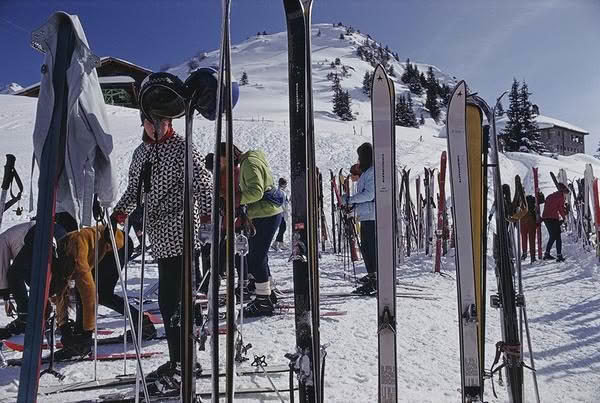 Skiers preparing gear on snowy mountain slope