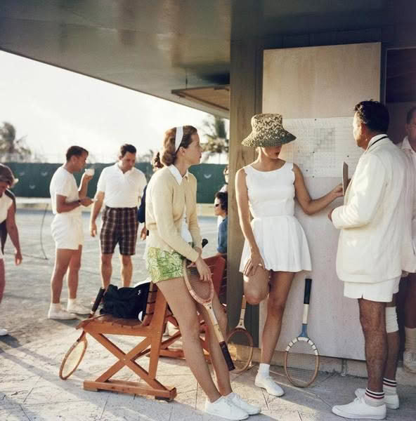 Vintage tennis players checking scores near court