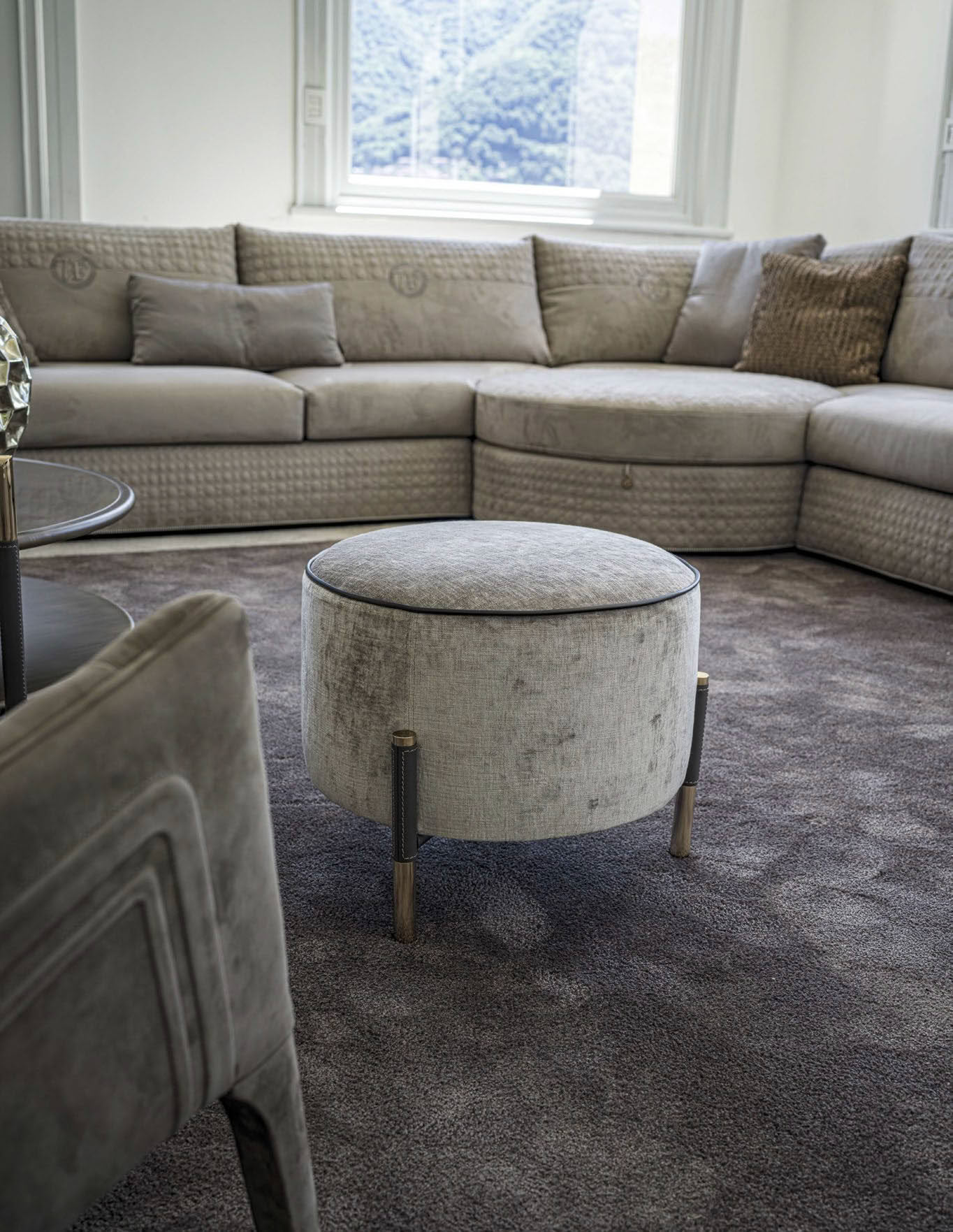Elegant living room with large sectional sofa and ottoman