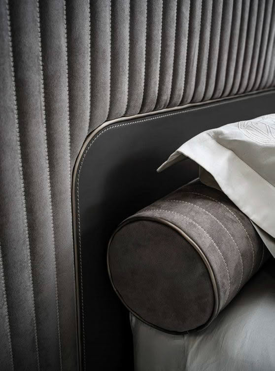 Elegant gray upholstered bed with stylish rolled pillow