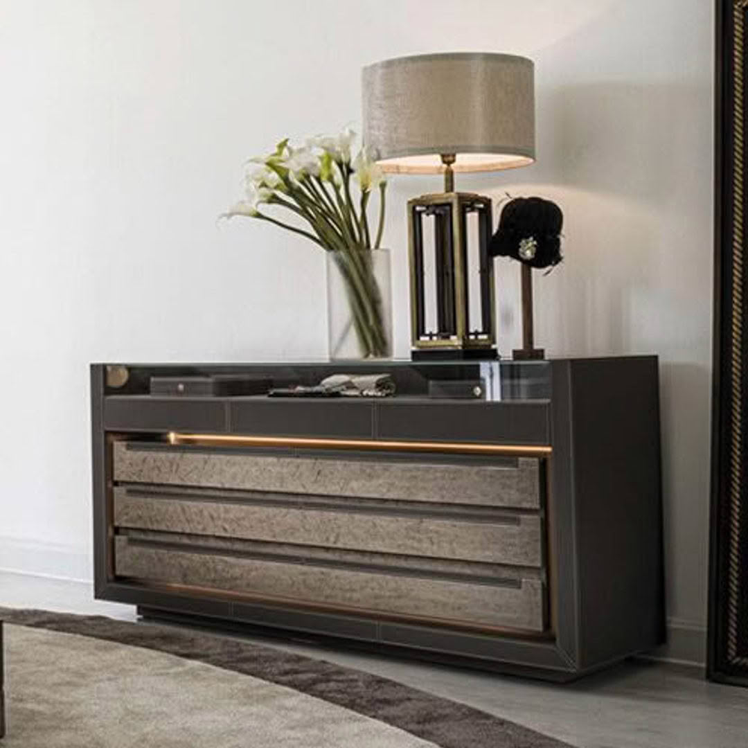 Modern dresser with lamp and flowers in elegant room