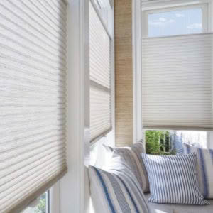 Cozy window seat with striped cushions and blinds