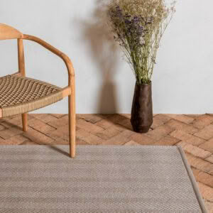 Wooden chair and vase with dried flowers on rug