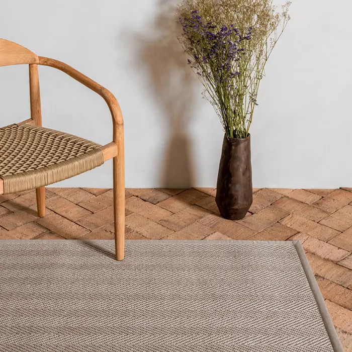 Wooden chair and vase with dried flowers on rug