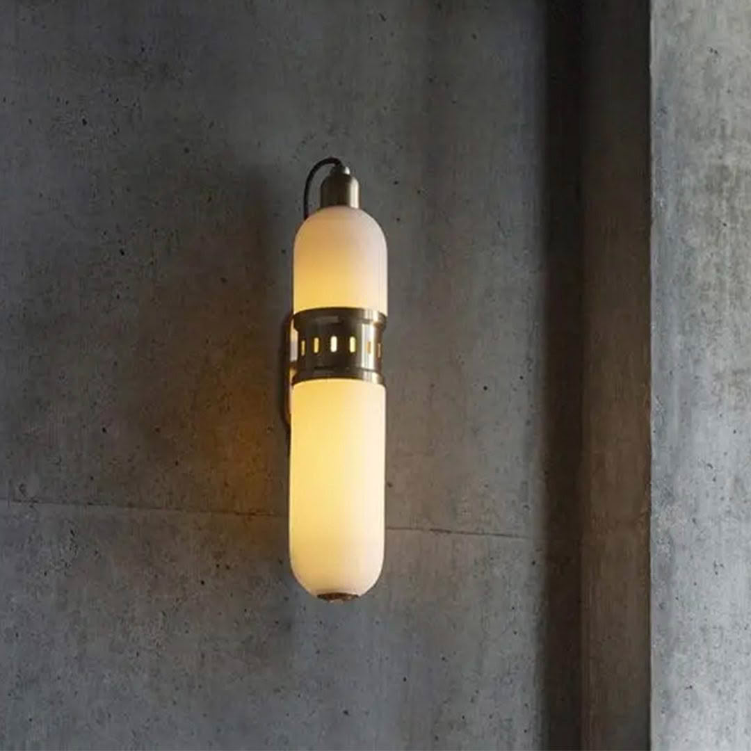Modern wall-mounted cylindrical light fixture on concrete