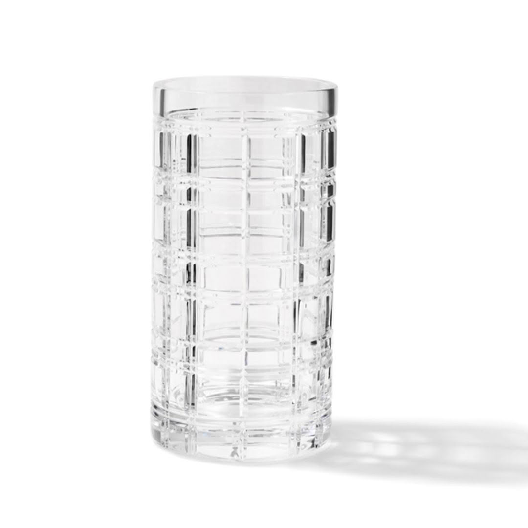 Clear geometric patterned glass tumbler on white background
