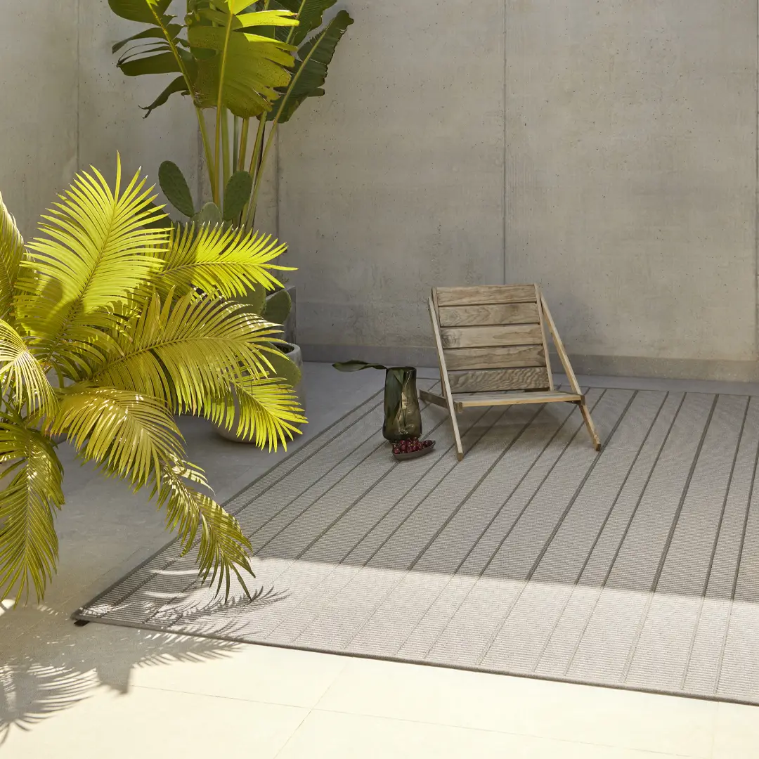 Sunlit patio with tropical plants and wooden chair