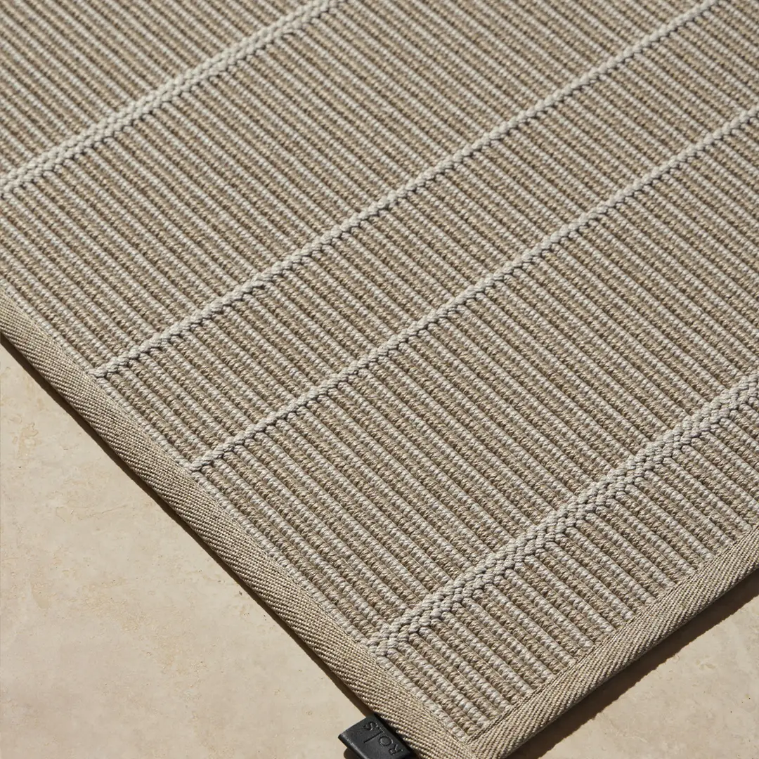 LYRA_2 Close-up of beige striped woven rug texture