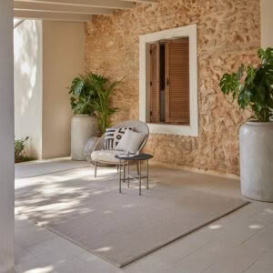 Cozy patio with chair, plants, and stone walls