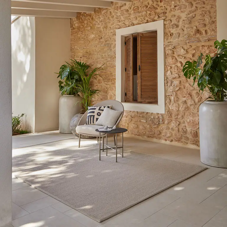 Cozy patio with chair, plants, and stone walls