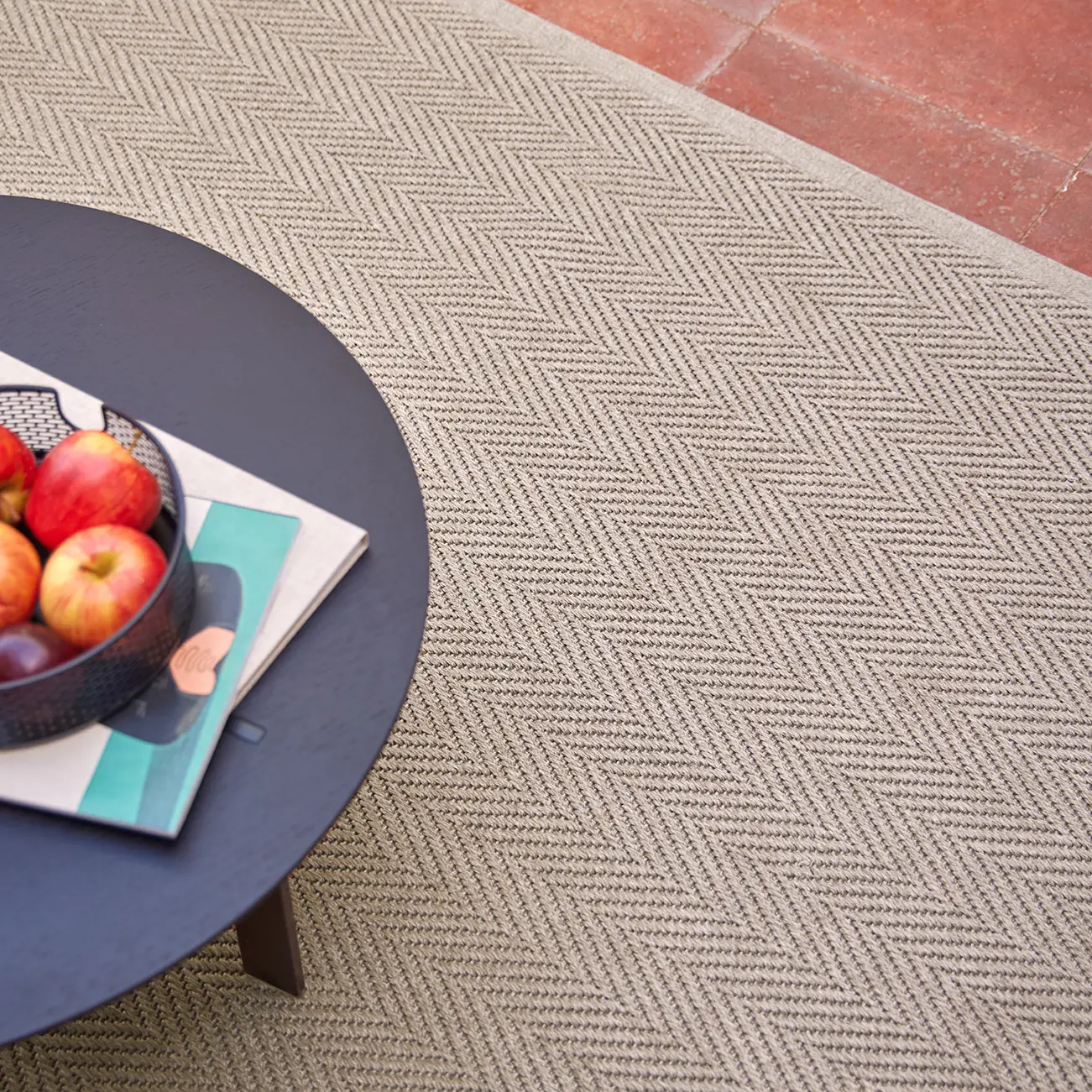 Circular table with fruit bowl on patterned rug